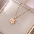 Collana a margherita dorata con smalto rosa e perla su un portagioie color champagne - Stile petalo rotante rosa chiaro (X3849)