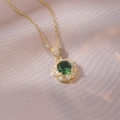 Elegant gold necklace featuring a green zircon flower pendant on champagne silk fabric - Green Flower Necklace (X3870)