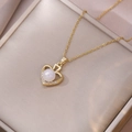 Elegante collana dorata con ciondolo a cuore perla e strass su portagioie in raso - Stile Cuore Cavo di Perla (X3859)