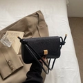 Bolso baguette negro con solapa brillante y detalles de herrajes dorados - Negro
