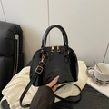 Elegante borsa a conchiglia in vernice nera con finitura lucida e dettagli in oro - Nero