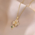 Collar con colgante de flor dorada con pétalos de circón blanco y hoja de piedra verde - Dorado