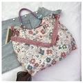 Detailed top view of a floral canvas tote bag with red checkered straps on white fabric - Red