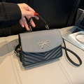 Bolso bandolera bicolor negro y crema con acolchado en V y lazo dorado elegante - Negro