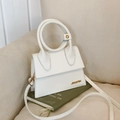 White small faux leather handbag with round handle and gold hardware on book - Off White
