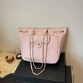 Sac à dos rose matelassé élégant avec sangles en chaîne et poche avant dans un cadre chic - Rose