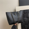Borsa tote nera con teschi a rilievo e catena dorata mostrata a mano - Nero