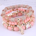 Detailed close-up of multi-layer beaded bracelets with pink beads and owl charm - Pink