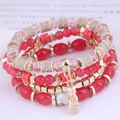 Detail of four-piece layered bracelet set with colorful beads and golden owl charm - Watermelon red