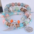 Details des Boho-Mehrschicht-Perlenarmbands mit Flügel- und Eiffelturm-Anhängern - Bunt