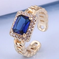 Makroaufnahme: Vergoldeter Ring mit blauem Zirkonia im Treppenschliff und Kettendesign - Blau (3#)