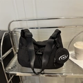 Black nylon crescent shoulder bag with drawstring detail and round coin purse charm - Black