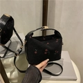 Black corduroy shoulder bag featuring red cherry embroidery and a gold-tone buckle - Black