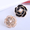 Detalle macro de elegantes pendientes de rosa y camelia con perlas y esmalte - Pendientes de botón negros