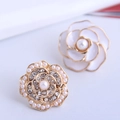 Primer plano de pendientes de camelia con esmalte blanco y cristales brillantes - Pendientes de botón blancos
