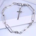 Détail macro d'un bracelet chaîne en argent vintage avec croix gothique et motifs soleil - Argent Antique - Style Croix
