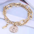Détail macro d'un bracelet doré à chaînes superposées avec pendentif et médaillon - Or - Style de pièce