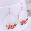 Detail von goldenen Creolen mit rosa Emaille-Blumen an einer weißen Keramiktasse - Goldener Blumenstil (1#)