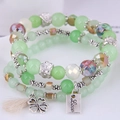 Close-up of triple-layered green bead bracelet with clover charm and Love metal tag - Style 5-Light Green White