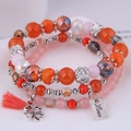 Dettaglio del bracciale a tre strati con perline, nappe arancioni e ciondoli a quadrifoglio - Stile 2-Arancione Rosa