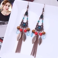 Detail of bohemian drop earrings with turquoise beads, bronze leaves and metal tassels - Triangle