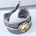 Detailed view of vintage silver feather ring featuring a yellow cat eye stone focal point - Yellow Dragon Eye Feather Style (2)