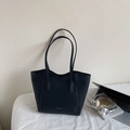Borsa tote nera minimalista con scritte dorate mostrata in un contesto da ufficio - Nero