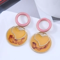 Detail of geometric round drop earrings with yellow translucent resin and gold heart frame - Pink Circle and Yellow Heart Round Drop (1)