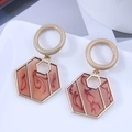 Detailed view of geometric hexagonal drop earrings with marble resin inlays on a tray - Beige Circle and Brown Hexagon Drop (3)