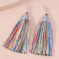 Detailed shot of ethnic style silver earrings with vibrant multi-colored silk tassels - Colorful
