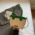 Chic beige woven straw bucket bag with dark green leather trim and shoulder strap - Green
