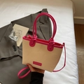Beige Stroh-Eimertasche mit pinkfarbenem Lederbesatz und geknotetem Tragegriff - Rosenrosa