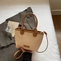 Bohemian straw handbag with brown leather trim and knotted handle detail in a home setting - Khaki