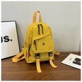Detail view of a bright yellow nylon backpack with buckle closure and side pockets - Yellow
