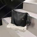 Sac seau noir minimaliste texture litchi avec bandoulière et pendentif logo argenté - Noir