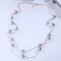 Détail d'un long collier doré double épaisseur avec perles grises et fermoir mousqueton - Gris