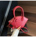 Vue détaillée du sac à main rouge en forme de croissant avec nœud décoratif et zip argenté - Rouge