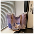 Detalle de bolso tote de lona morada con bordes de flecos y estampados florales abstractos - Púrpura