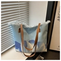 Detalle del bolso tote de lona azul claro con estampado de nubes y bordes deshilachados modernos - Azul