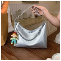 Detail of silver metallic hobo bag featuring geometric metal chain and a cute charm - With Charm / Silver