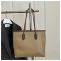 Detail of a large khaki tote bag with dark brown straps hanging on a metal rack - No Pendant / Khaki