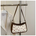 Detail view of a cherry print shoulder bag with brown faux leather trim and chain strap - Brown