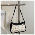 Detailed close-up of retro cherry print baguette bag with black trim and chain - Black