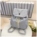Close-up of lightweight plaid drawstring backpack with yellow cords on white display stand - White Checkered