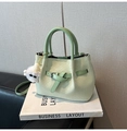 Light green woven handbag with dark green handles and a white plush charm - With Charm / Green