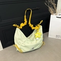 Hellgrüne Nylon-Halbmondtasche mit gelbem Kordelzug-Gurt und Blumen-Anhänger-Detail - Grün mit Anhänger