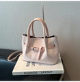 Detailed view of pink woven texture handbag with shoulder strap on minimalist white book - No Pendant / Pink