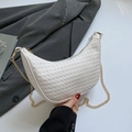 Weiße Crescent-Tasche mit Webmuster und Goldkette vor einem grauen Anzugjackett - Weiß