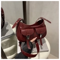 Gros plan d'un sac sous le bras en cuir verni bordeaux avec poches à boucles argentées - Rouge