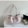 Detail of light beige woven tote bag with buckled straps on a desk with a laptop - Pink